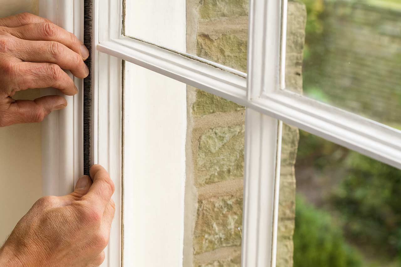 Installing new draught proofing seals on a timber sash window.