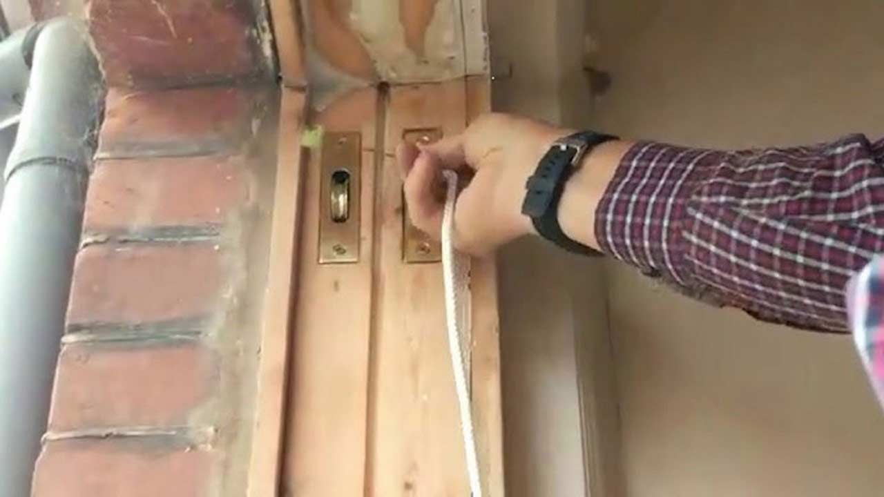 Sash cords and pulleys system being repaired to restore smooth movement